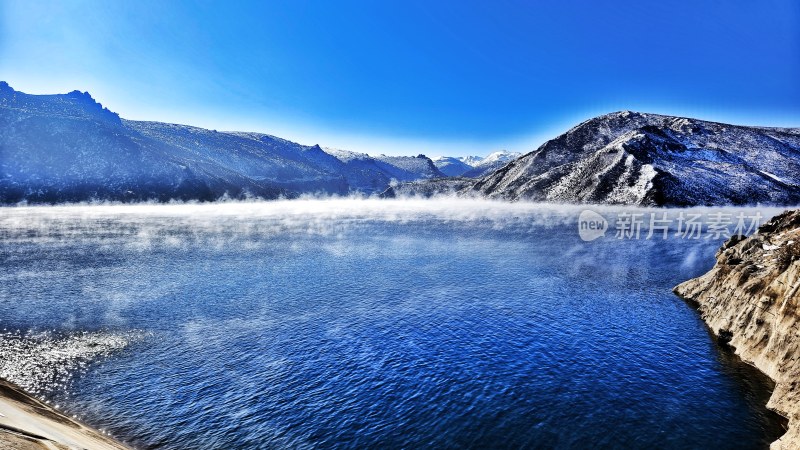 雪山下雾气腾腾的湖泊自然风景