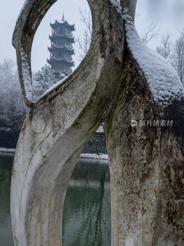 透过积雪雕塑框住的古塔风景