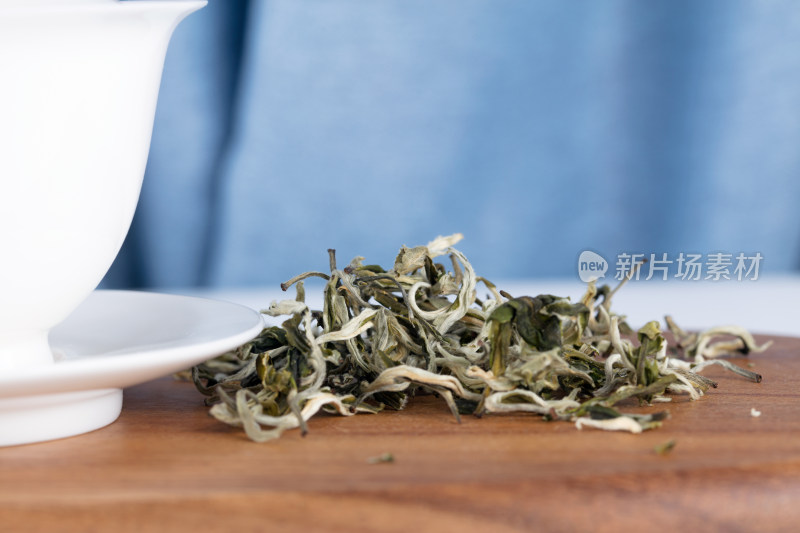 砧板上茶碗旁的绿茶茶叶