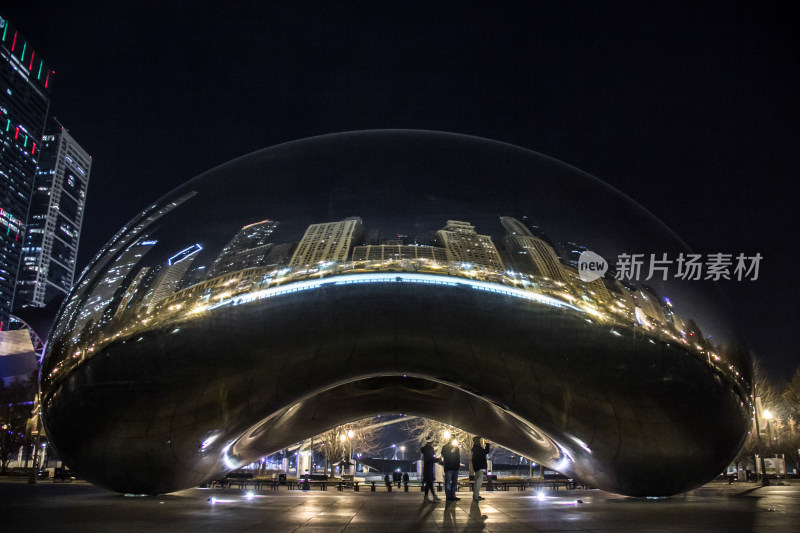 夜晚的芝加哥云豆雕塑倒影出城市建筑