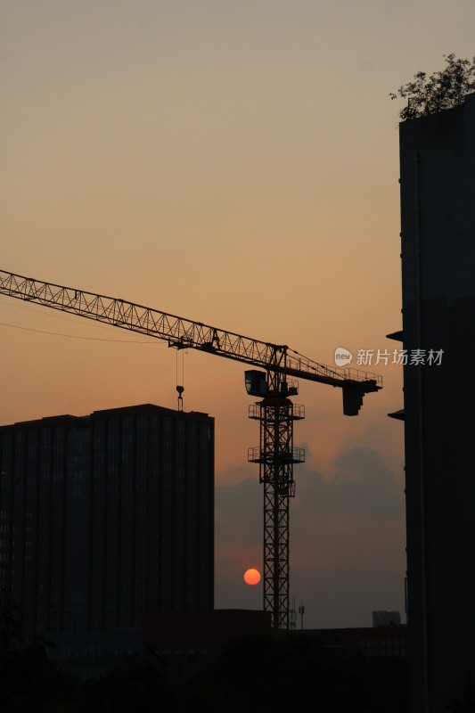 夕阳下的城市建设者——塔吊与日的对话