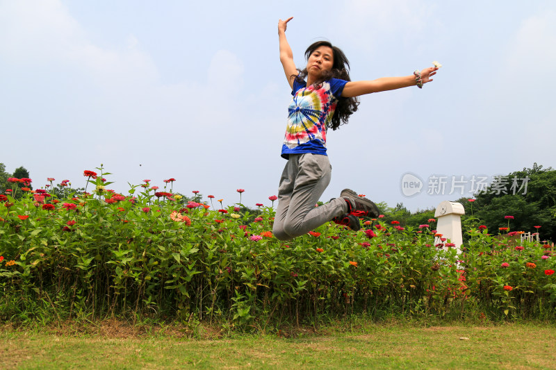 女子在花丛中跳跃