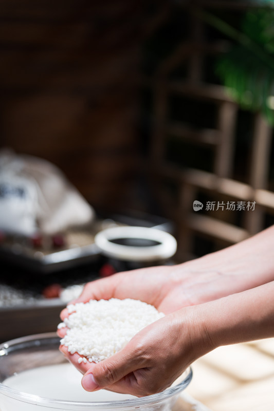 手工包制粽子过程淘洗糯米的女性手部特写