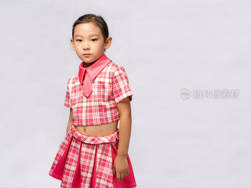 站在纯色背景前穿短裙的中国女孩