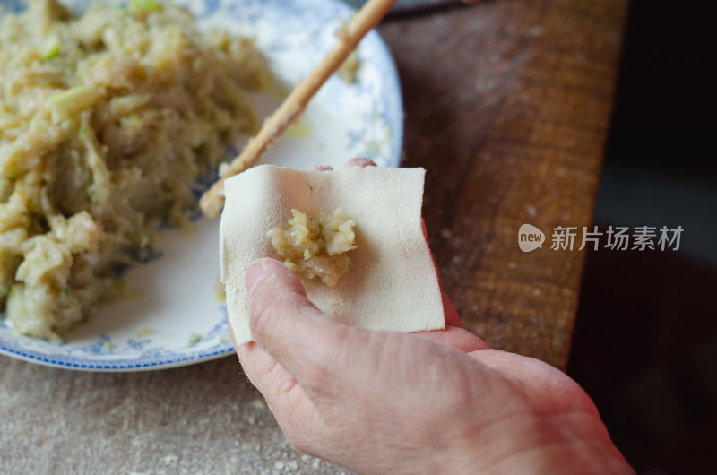 木案边包馄饨手部特写