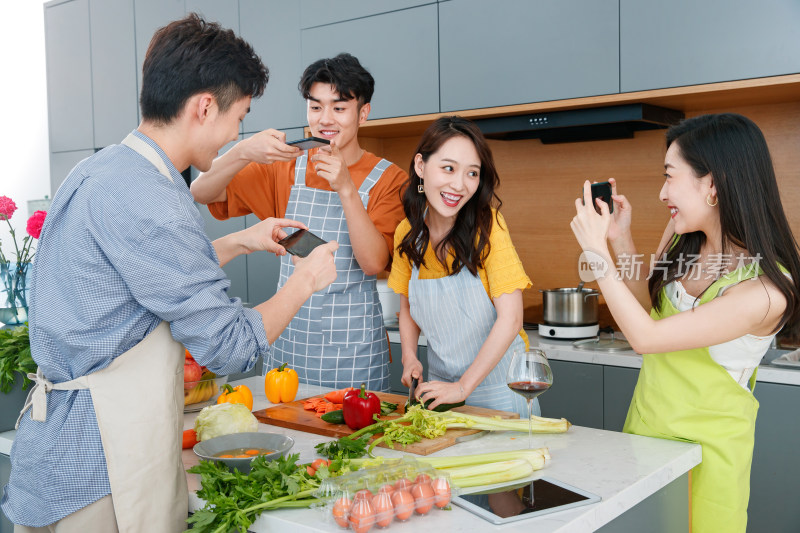 快乐的年轻人在厨房做饭照相