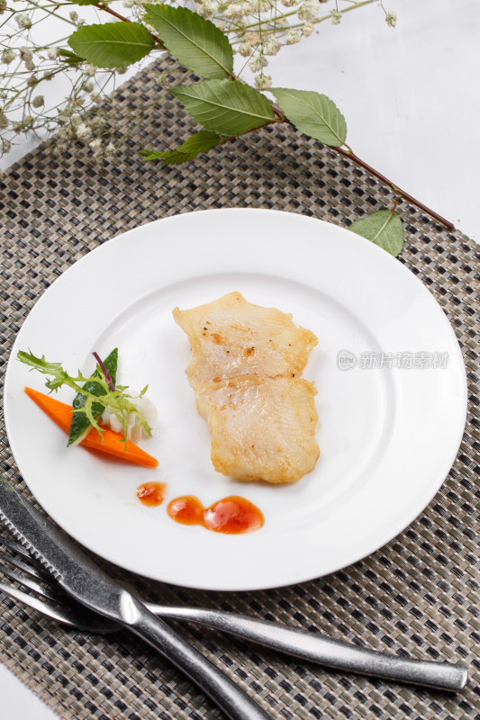 日式铁板煎石斑鱼摆放在餐垫上