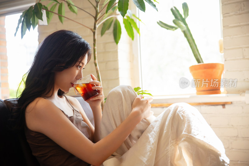 年轻女人在家喝茶休息