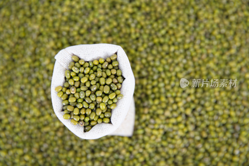 俯视一堆绿豆背景和其上一袋绿豆