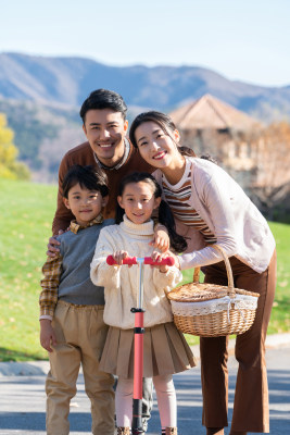 年轻夫妻带着孩子们在玩滑板车