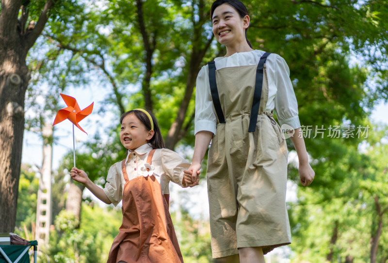 妈妈拉着女儿的手开心向前奔跑