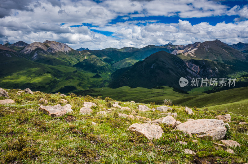 蓝天白云下广袤草原与连绵山峦自然风景