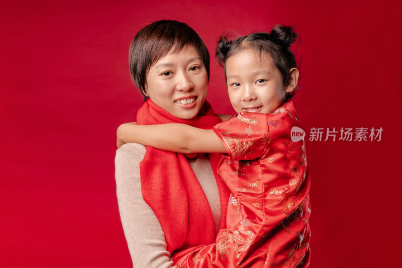 站在红色背景前的中国母女