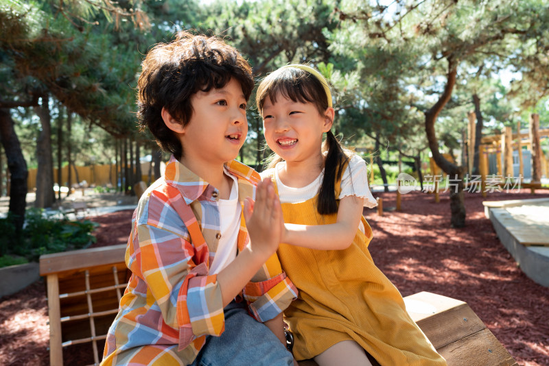 两个小孩子开心击掌庆祝