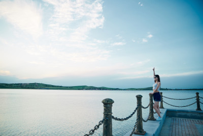 盛夏夕阳晚霞湖边码头看风景的少女