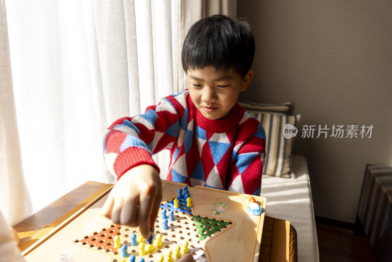 中国小孩在窗边下棋跳跳棋