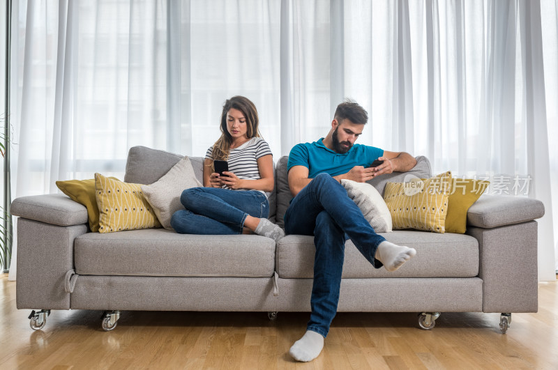 情侣在家沙发上玩手机