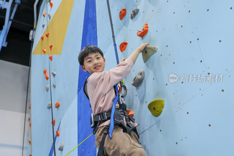 小男孩在室内游乐场练习攀岩