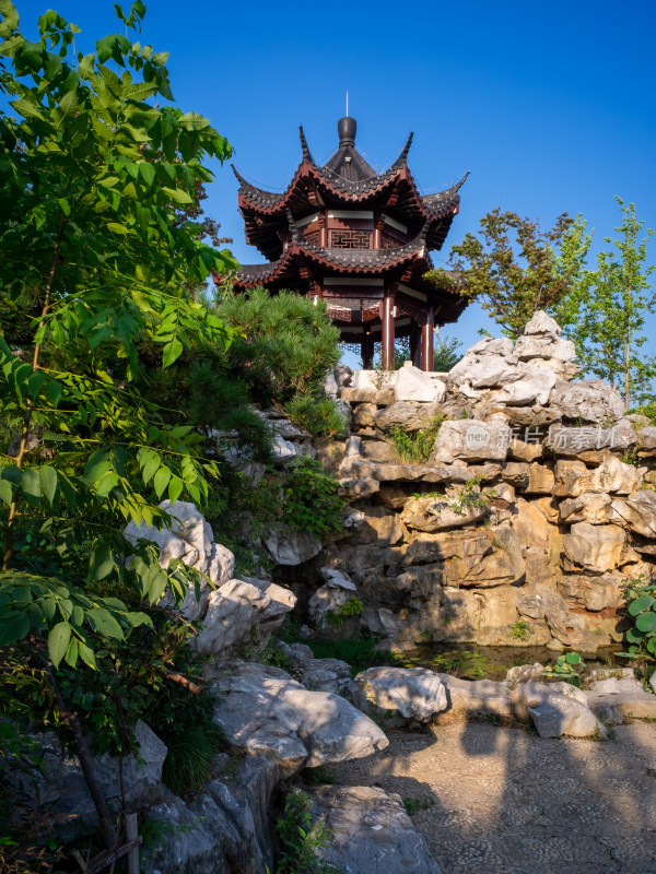 传统中式亭阁置于山石绿植间的景象