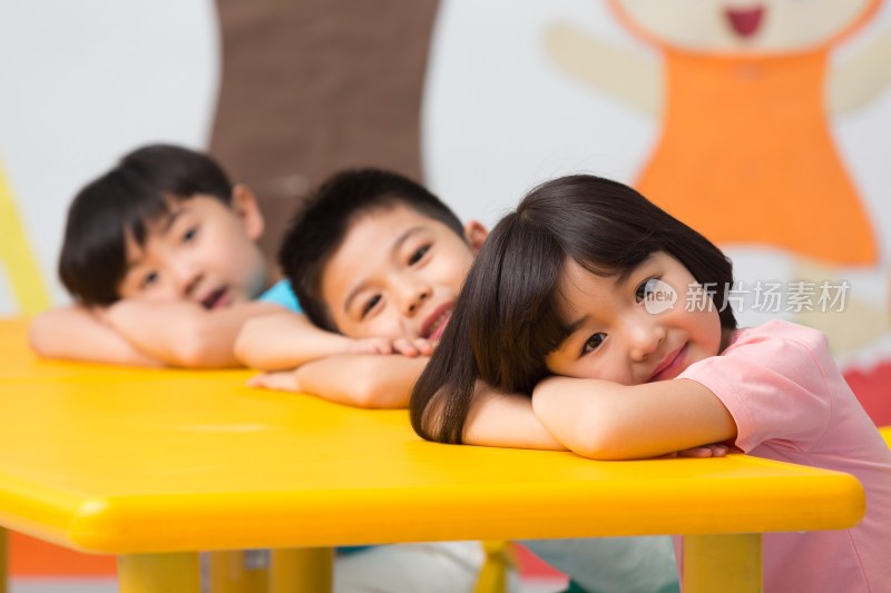 幼儿园儿童趴在桌子上微笑