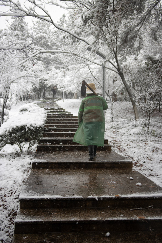 雪中穿着雨衣的人走在户外台阶上