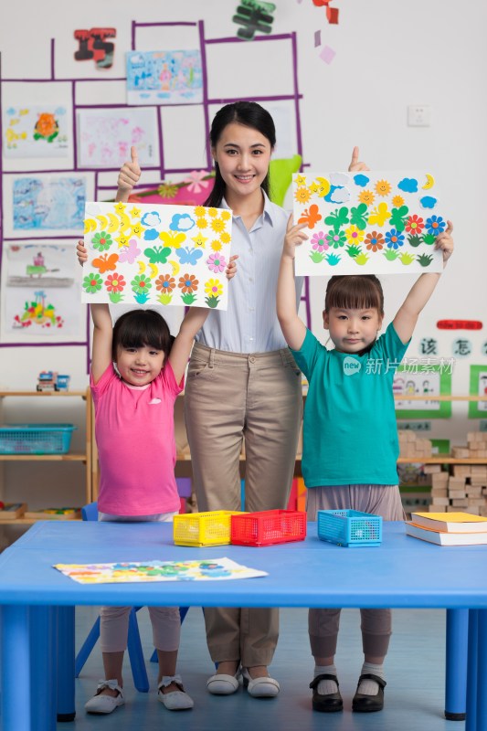 幼儿园女老师和儿童展示手工儿童画