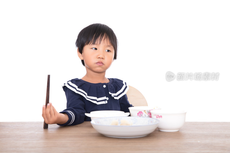 白背景前吃着饭连带卖萌的中国小女孩