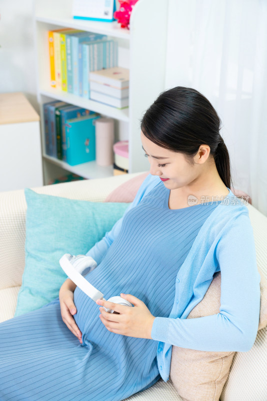 孕妇把耳机放在肚子上