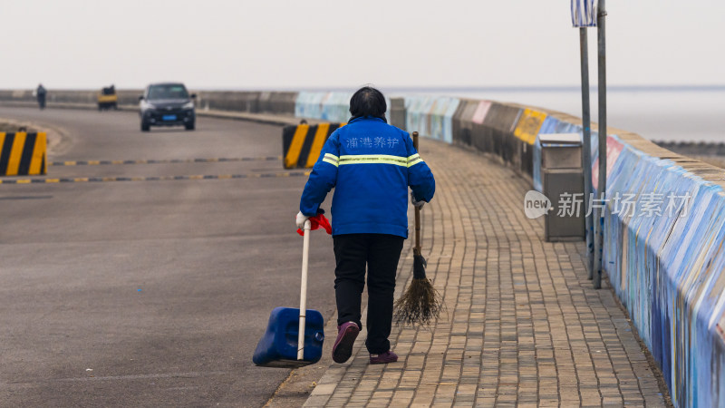 穿着养护服的环卫工人清扫道路