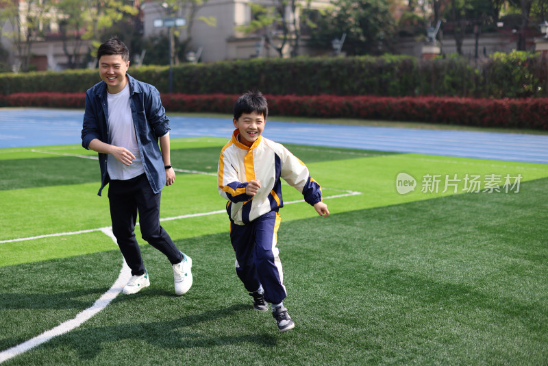 父亲和儿子在足球场上踢球