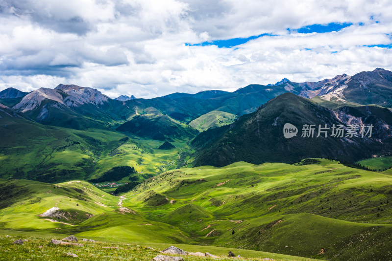 蓝天白云下广袤草原与连绵山峦自然风景