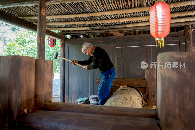 传统油坊榨油老人抡大锤劳作