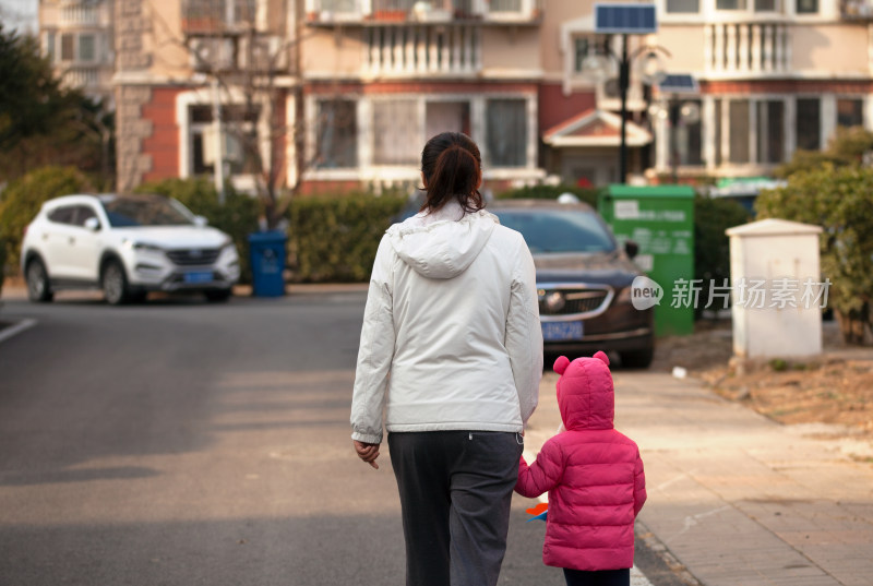 小区里妈妈牵着孩子背影