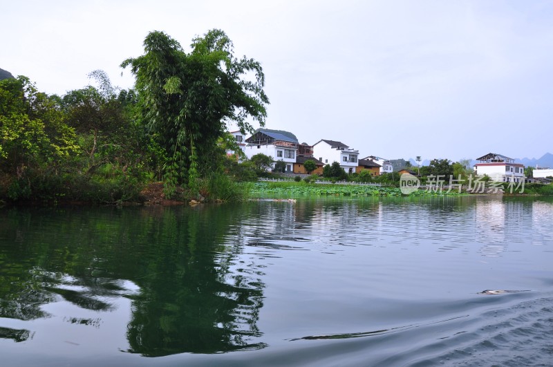 桂林世外桃源景区河水两岸树木和建筑民居