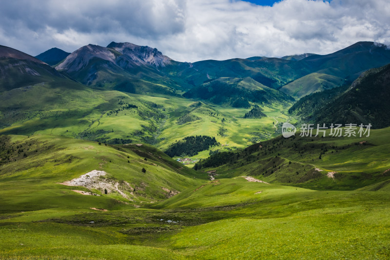 蓝天白云下广袤草原与连绵山峦自然风景