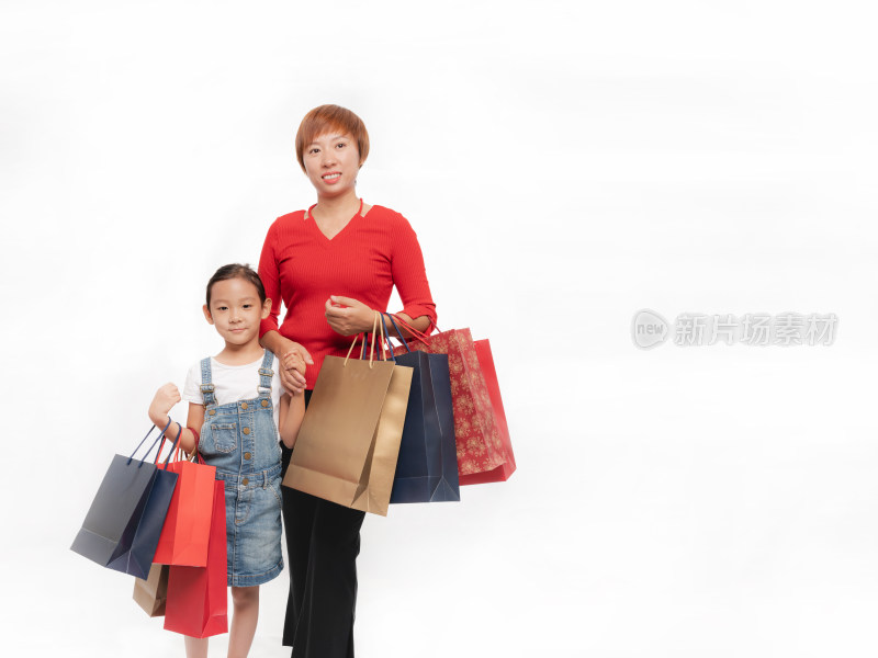 站在白色背景前手提购物纸袋的母女