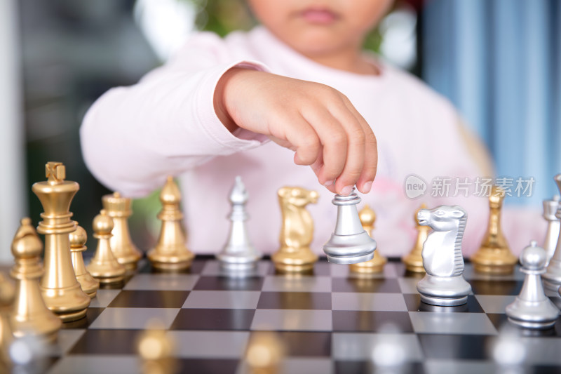 小手拿着国际象棋棋子在棋盘上下棋