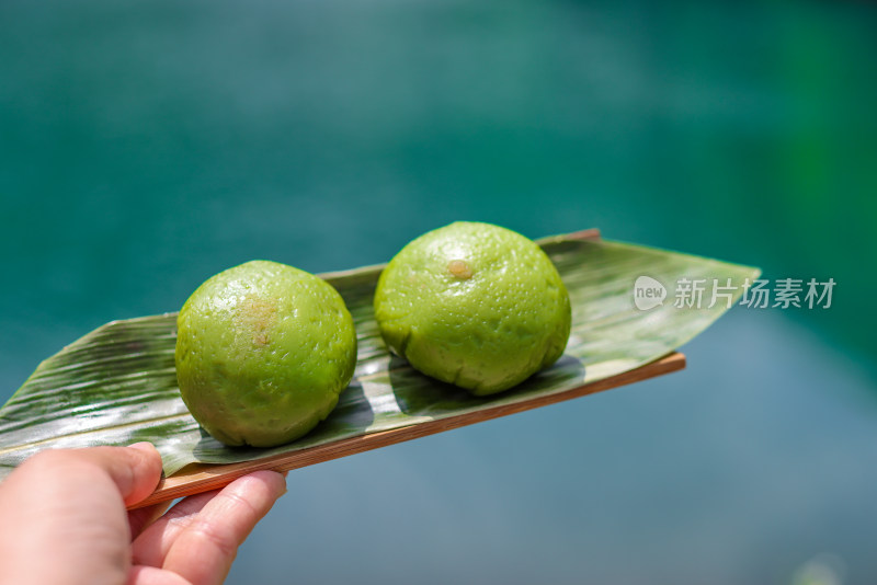 在湖边手拿青团的特写