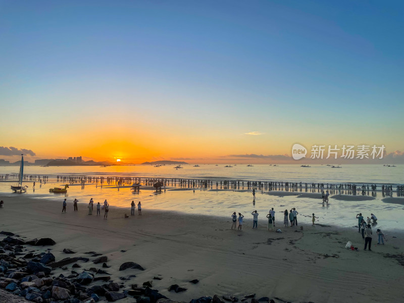 夕阳下热闹的海滩场景