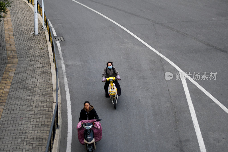 道路上骑行电动车的行人