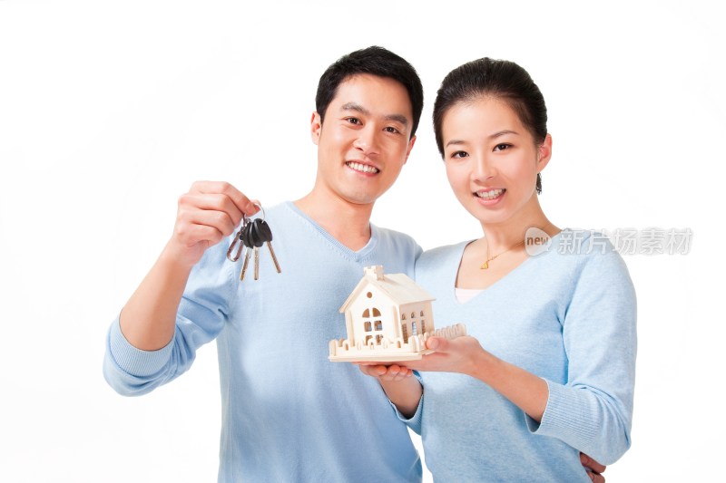 幸福的夫妻拿着钥匙和房子模型