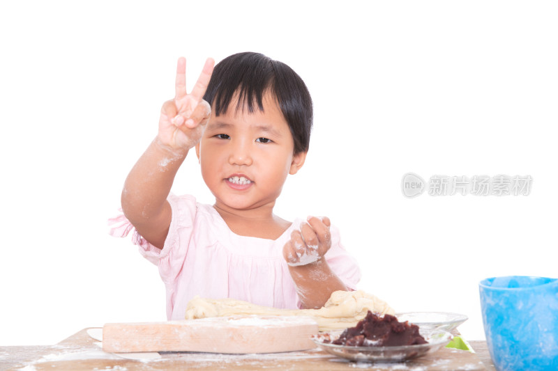 可爱的小女孩做月饼期间抬头看镜头做手势