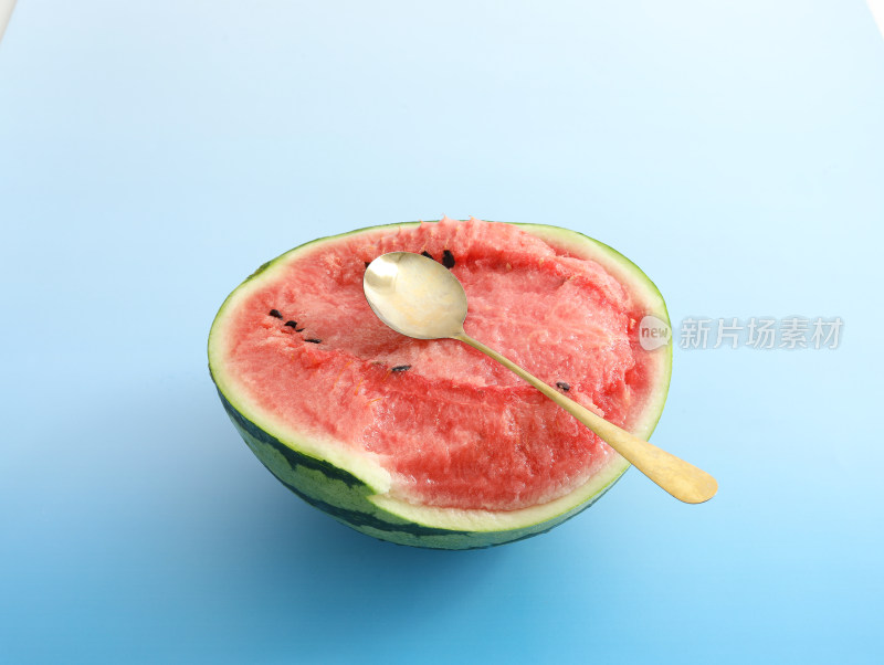 蓝色背景上，用勺子挖西瓜吃的夏日乐趣