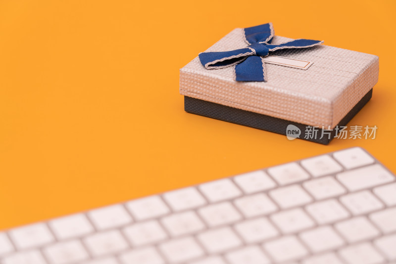 电商网购概念黄色背景上礼品盒和电脑键盘