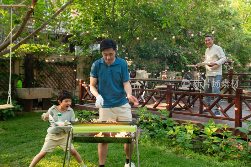 幸福父子在庭院内烧烤