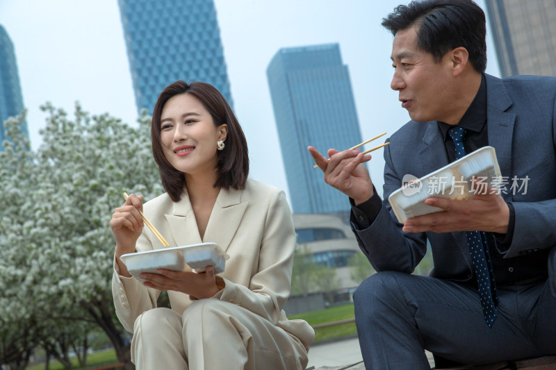 商务人士坐在户外吃盒饭