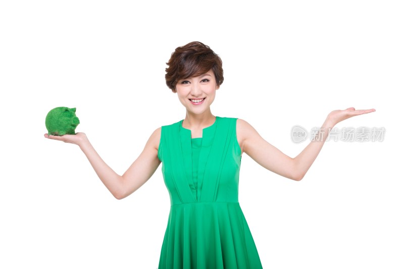 穿绿色裙子的年轻女人拿着绿色小猪存钱罐