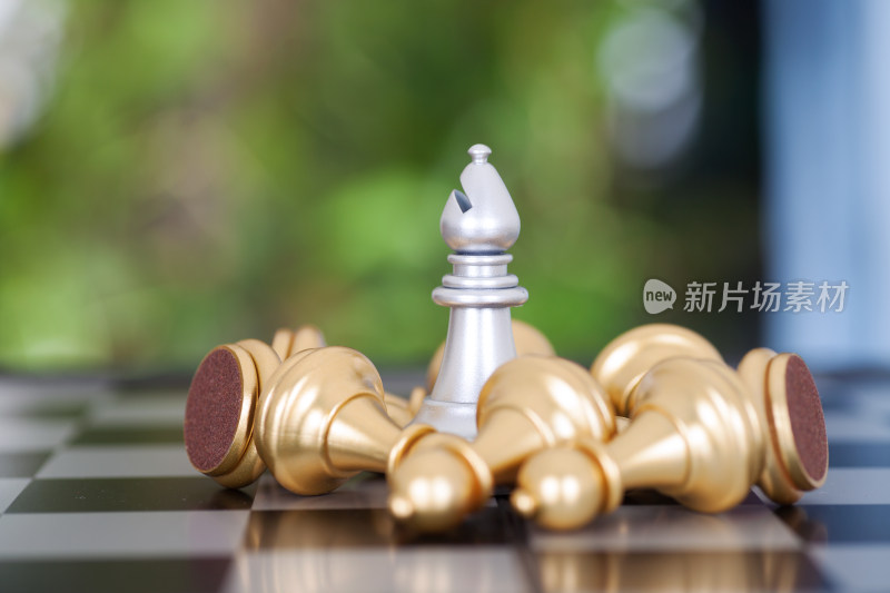 一堆金色兵棋子围绕的银色象棋子