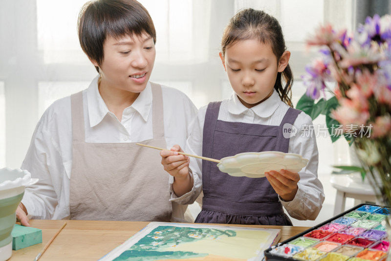陪伴教导女儿绘画的中国母亲