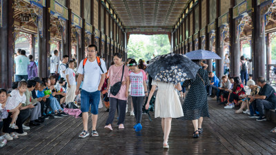 游客们冒雨游览成都都江堰景区